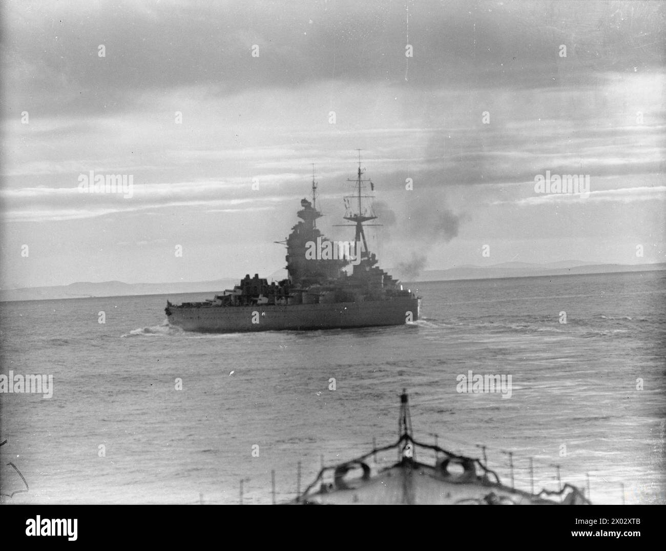 En 1940, le HMS Nelson, un cuirassé de la Royal Navy, tire ses canons arrière de 4,7 pouces en mer. Banque D'Images