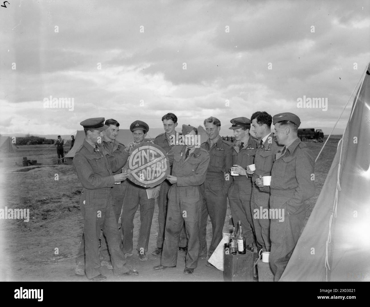 OPÉRATIONS DE LA ROYAL AIR FORCE AU MOYEN-ORIENT ET EN AFRIQUE DU NORD, 1939-1943. - Flying Officer d H Greaves (à l'extrême gauche) et Adjudant F M Robbins (cinquième à partir de la gauche), une équipe de combat nocturne réussie de Bristol Beaufighter avec le No. 255 Squadron RAF, montrent un trophée coupé à leur cinquième victime, un Cant Z1007 qu'ils ont intercepté au-dessus d'os dans la nuit du 18/19 janvier 1943, à d'autres membres de l'escadron à Sétif, Algérie. Le groupe comprend le commandant du N° 255, le commandant de l'escadre d P d G Kelly, debout deuxième à partir de la droite. Greaves (pilote) et Robbins (opérateur radar) ont Uni leurs forces whil Banque D'Images