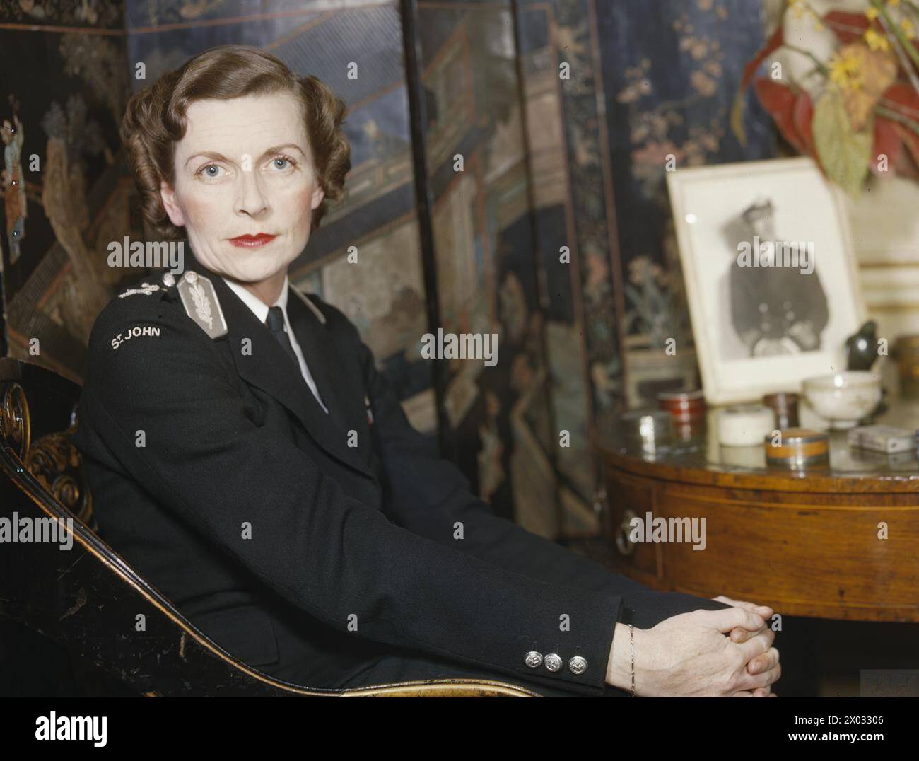 Lady Mountbatten est représentée dans l'uniforme de la brigade de l'Ambulance Saint-Jean, assise à côté d'une petite table ronde dans son salon Belgrave Square, Londres, pendant les fonctions infirmières de la seconde Guerre mondiale. Banque D'Images