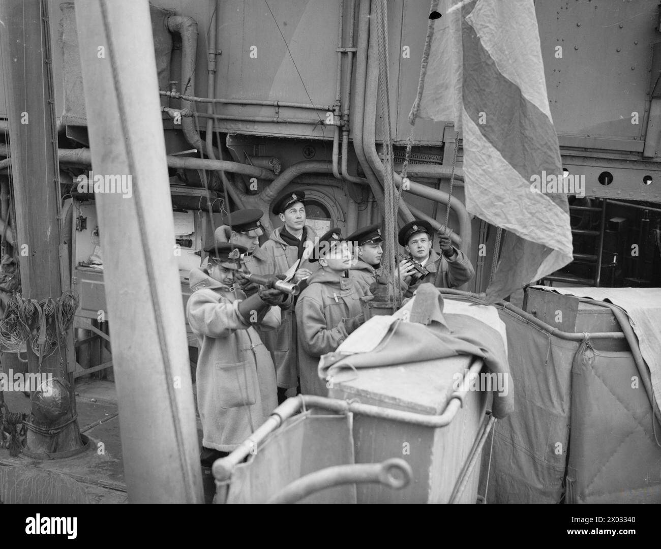 Des aspirants-navires polonais et indiens sont montrés sur le pont de signalisation du HMS Suffolk en 1941, apprenant à connaître les drapeaux et les pendentifs de la marine dans le cadre de leur entraînement avant de rejoindre leurs marines respectives. Banque D'Images