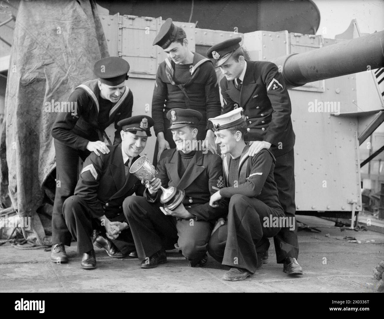 Le personnel naval grec et britannique admire une coupe en argent inscrite présentée au HMS Salamis par la Royal Hellenic Navy le 31 janvier 1944 à Liverpool en reconnaissance du sauvetage des survivants d'une attaque de U-boot. Banque D'Images