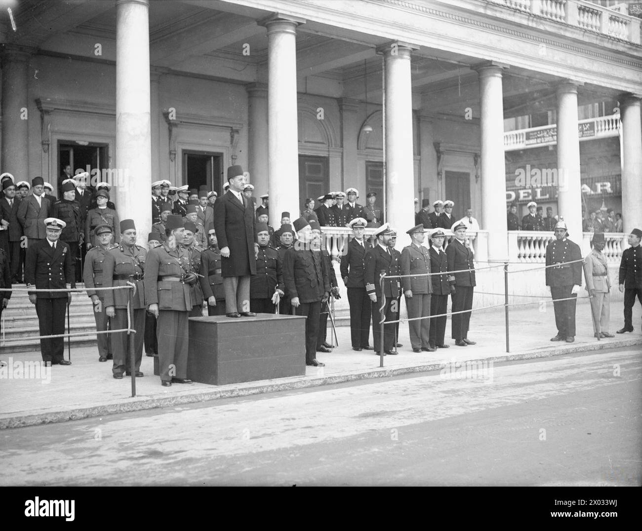 Des officiers de la marine britannique assistent à la parade d'anniversaire du roi Farouk à Alexandrie en février 1945, observant la marche de l'armée égyptienne et de la défense civile. Banque D'Images