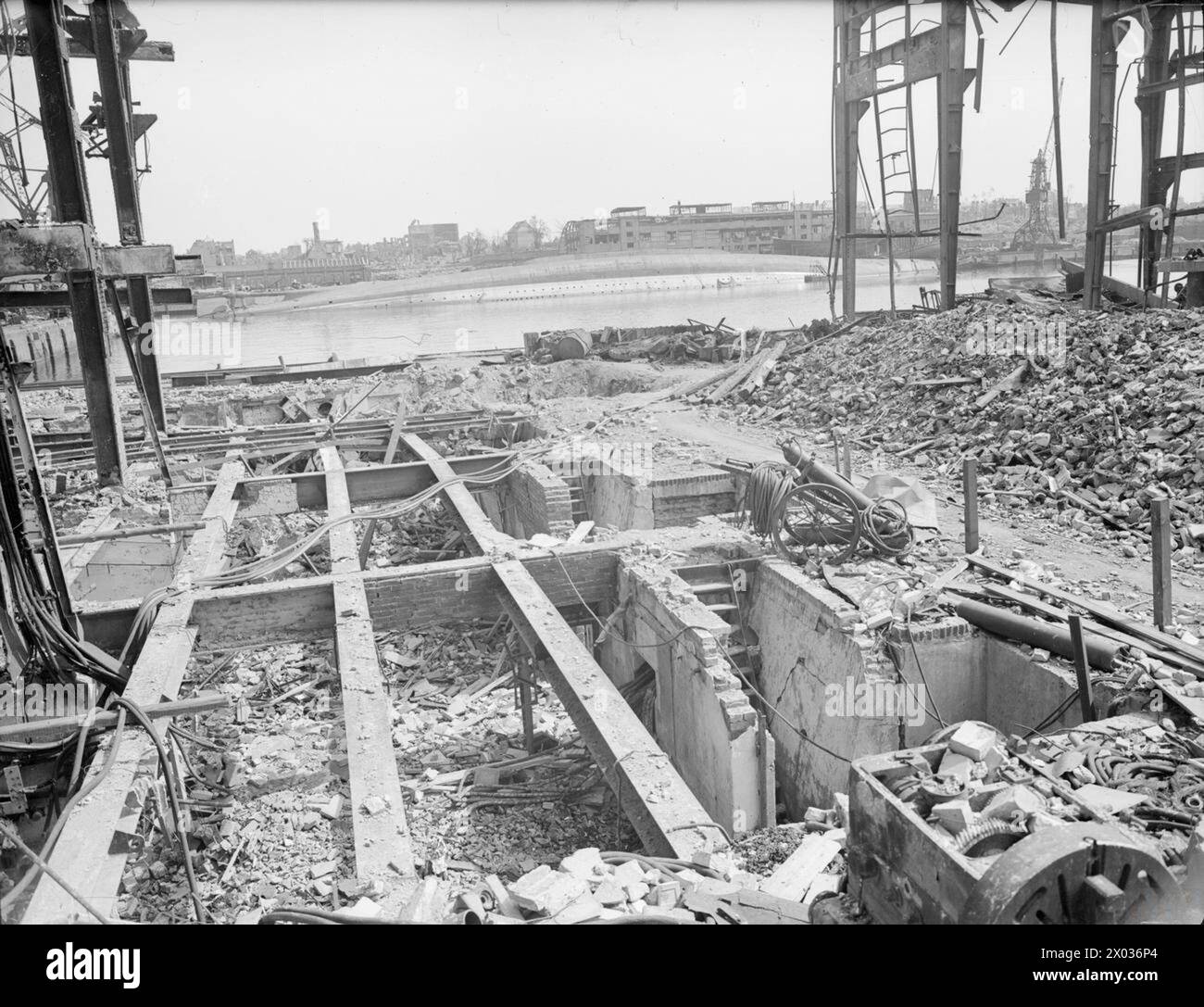 LA MARINE PREND LE RELAIS À KIEL. DU 6 AU 12 MAI 1945, LA BASE NAVALE ALLEMANDE DE KIEL APRÈS QUE LA ROYAL NAVY L'EUT REPRISE. - L'AMIRAL Scheer chaviré vu d'une usine de U-Boot détruite par les bombardements de la RAF Banque D'Images