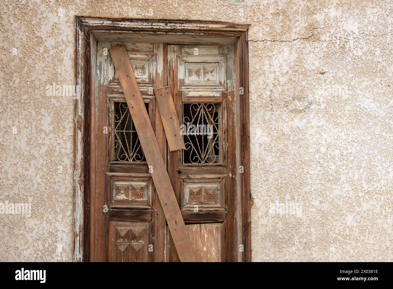 Des planches couvrent une porte arborée sur une maison arabe abandonnée au moyen-Orient. Banque D'Images