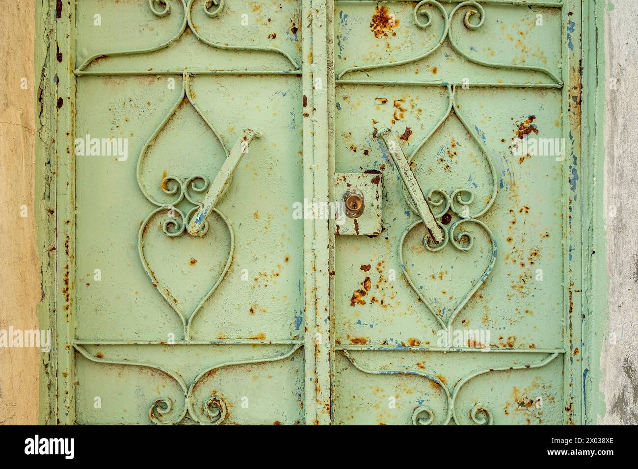 Une porte en métal vert altéré avec de la peinture écaillée à l'entrée d'une vieille maison arabe au moyen-Orient. Banque D'Images