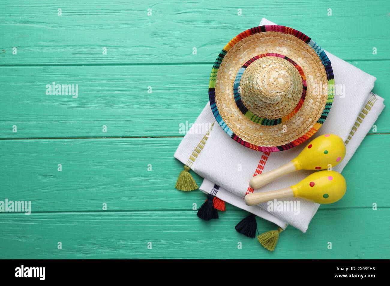 Chapeau sombrero mexicain, maracas et poncho sur table en bois turquoise, pose à plat. Espace pour le texte Banque D'Images
