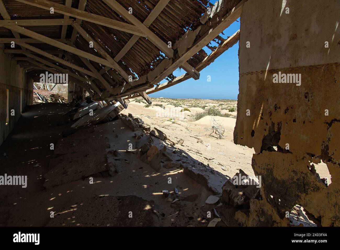 À l'intérieur de la piste de bowling effondrée du village minier de Bogenfels, Namibie, montrant le désert de Tghe au-delà. Banque D'Images