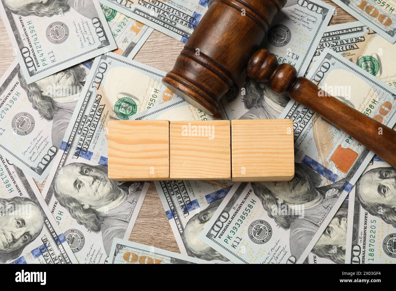 Droit fiscal. Cubes en bois vierges, billets de banque dollar et marteau sur la table, vue de dessus Banque D'Images