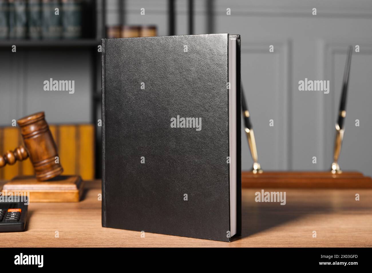 Droit fiscal. Livre, calculatrice et marteau sur table en bois Banque D'Images