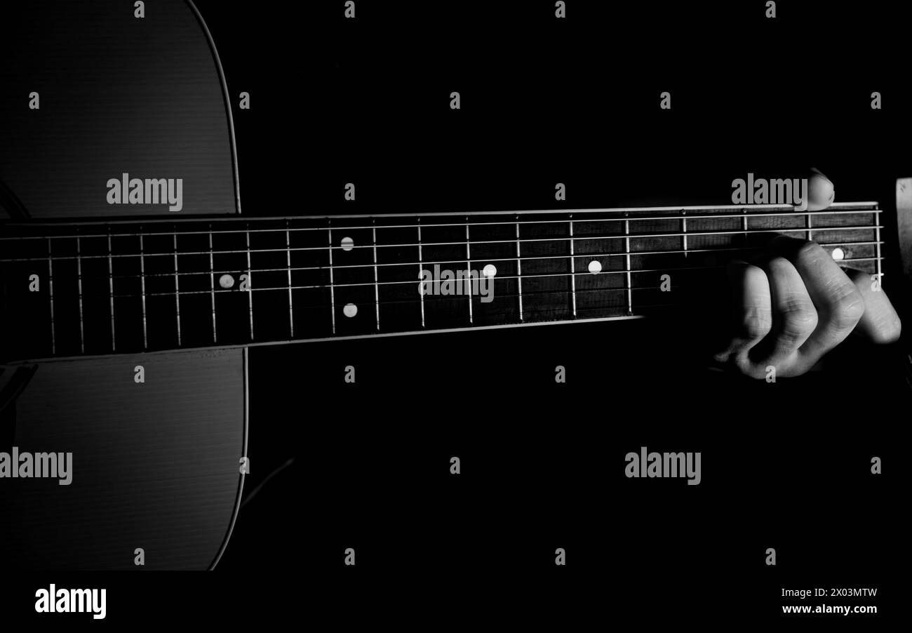 Les mains d'un homme jouant de la guitare acoustique. Fond musical Banque D'Images