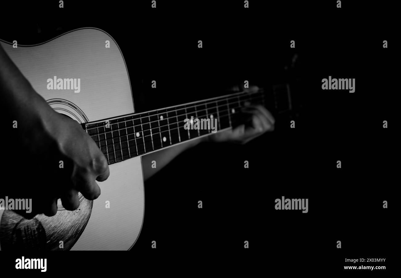 Les mains d'un homme jouant de la guitare acoustique. Fond musical Banque D'Images