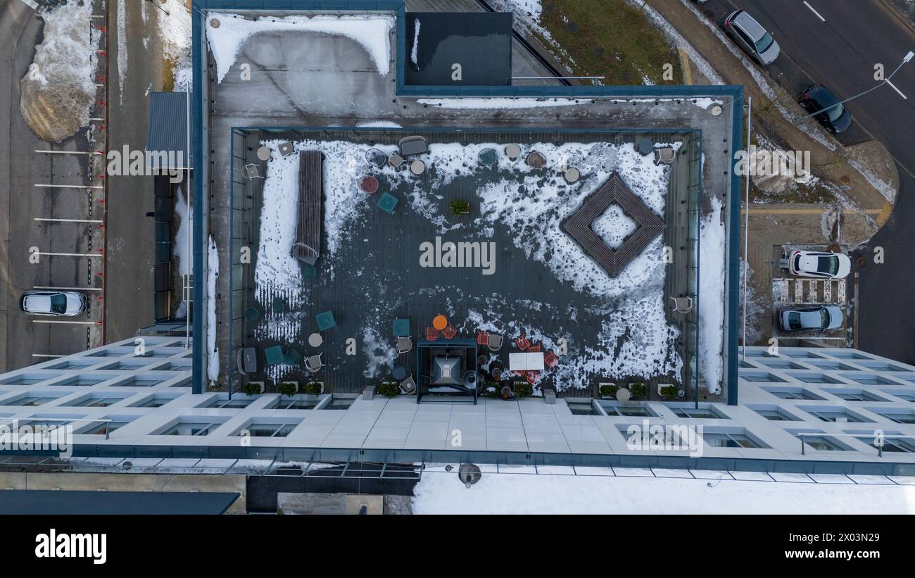 Photographie par drone de terrasse sur le toit dans un immeuble de bureaux couvert par la neige pendant la journée ensoleillée d'hiver Banque D'Images