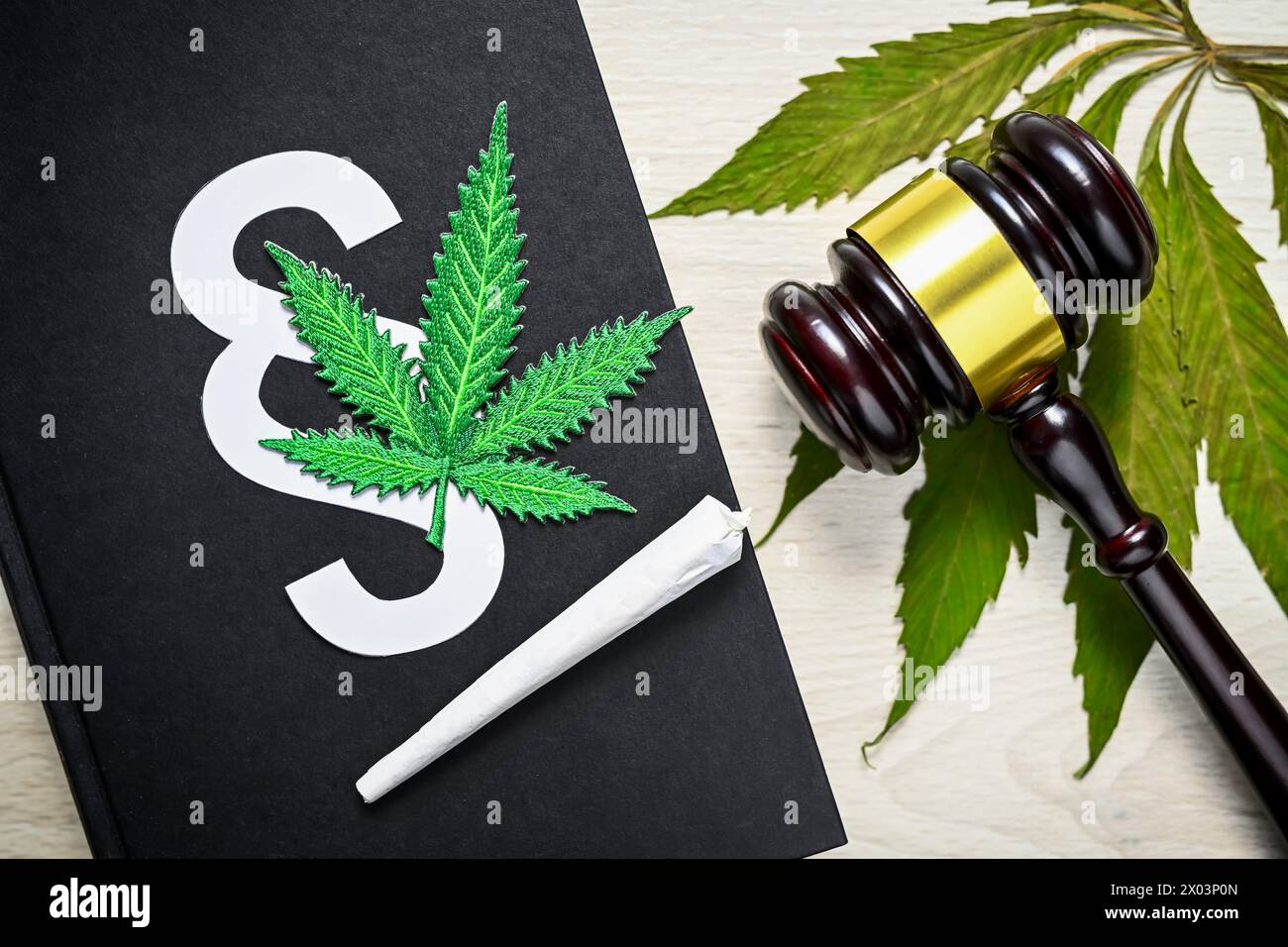 Feuille de cannabis et joint sur un livre de droit avec un marteau de juge, légalisation du cannabis Banque D'Images
