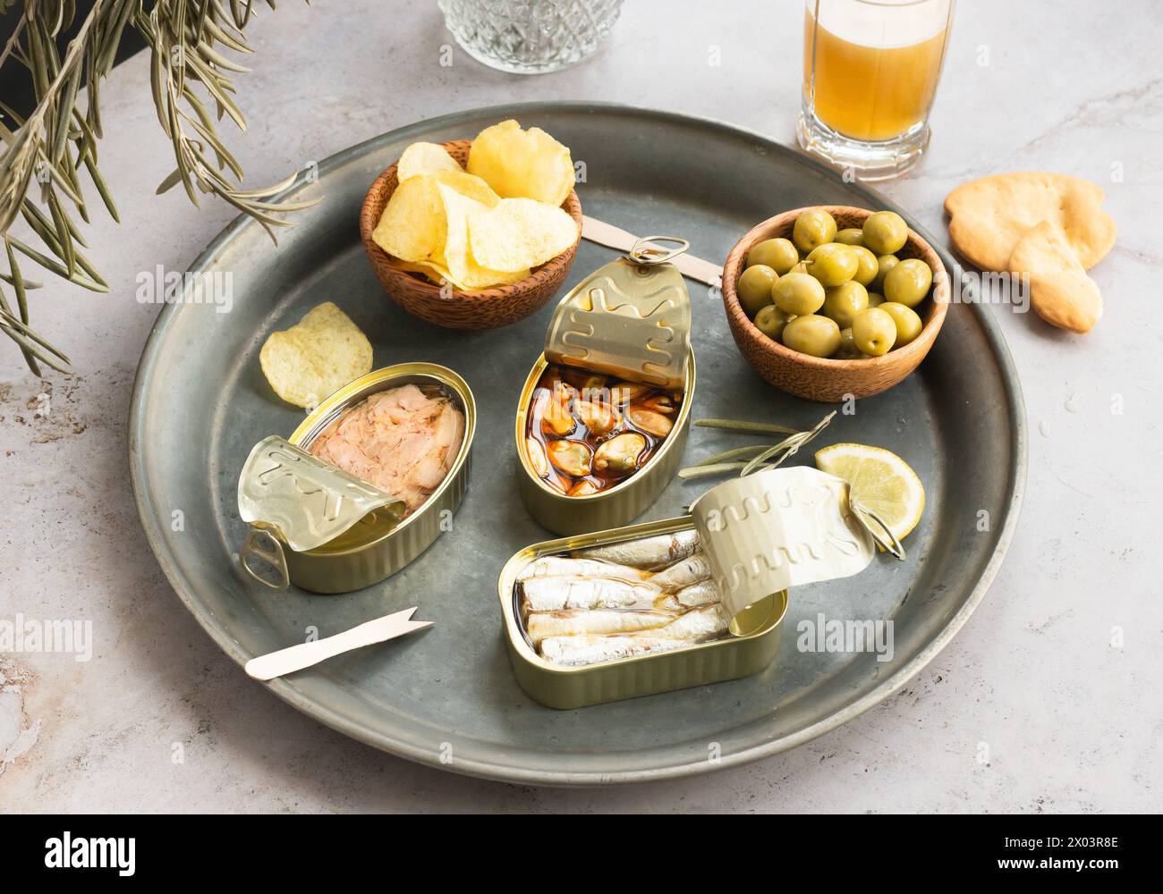 Apéritif sur plateau avec poisson en conserve, olives, frites, bière, vermouth pour le buffet. Prêt à servir l'été. Copier l'espace. Banque D'Images