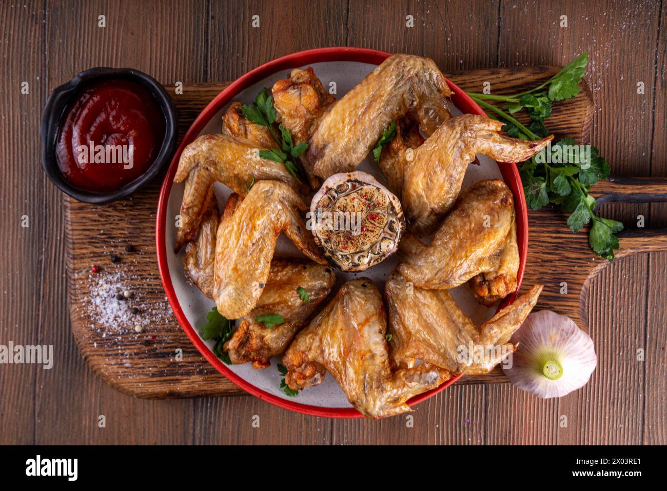 Ailes de poulet grillées rôties au barbecue avec sauce ketchup et condiments, ailes de volaille au barbecue maison Banque D'Images