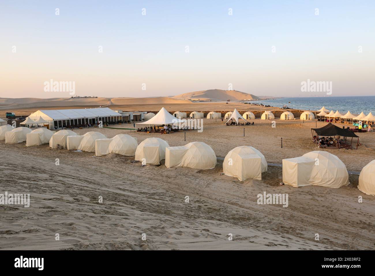 Tentes au camp du désert QIA à la mer intérieure dans le golfe Persique au coucher du soleil. Moyen-Orient, péninsule arabique. La mer intérieure est une destination touristique majeure. Qatar Banque D'Images