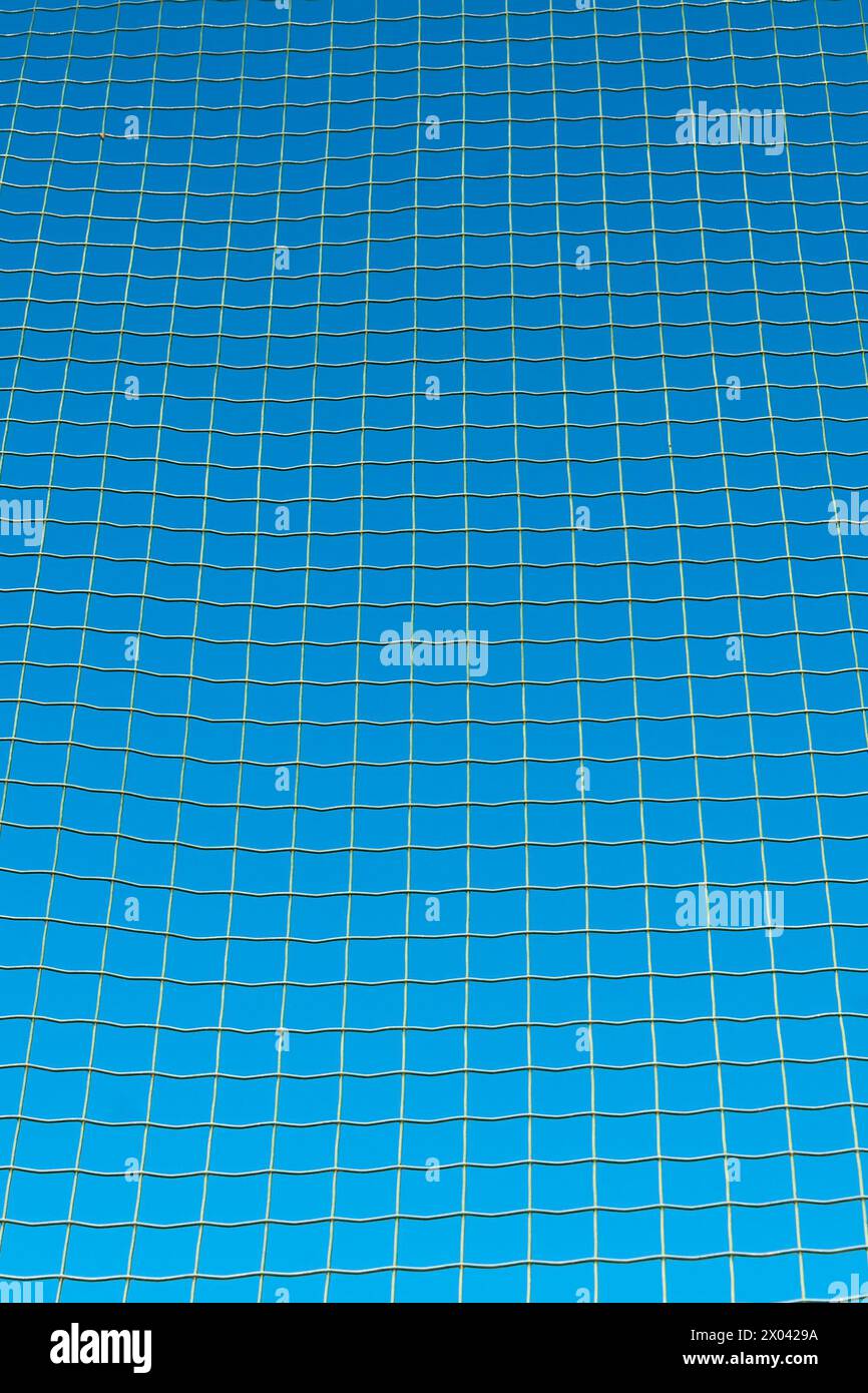 Treillis métallique, clôture. Arrière-plans et textures. Ciel bleu. Détails et éléments. Banque D'Images