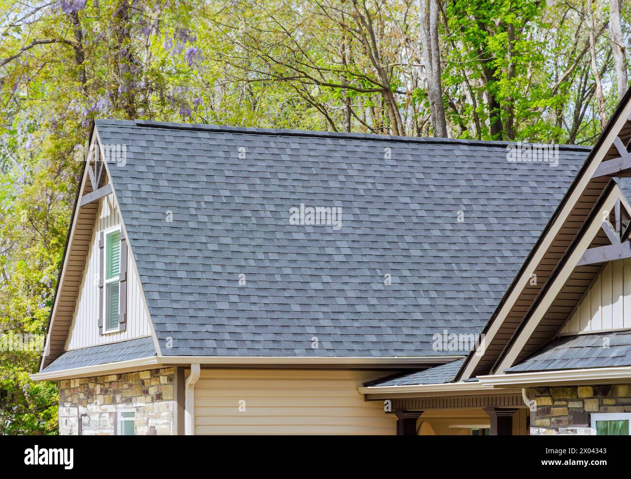 Les bardeaux d'asphalte sont utilisés comme matériaux de toiture sur le toit de la maison nouvellement construite Banque D'Images