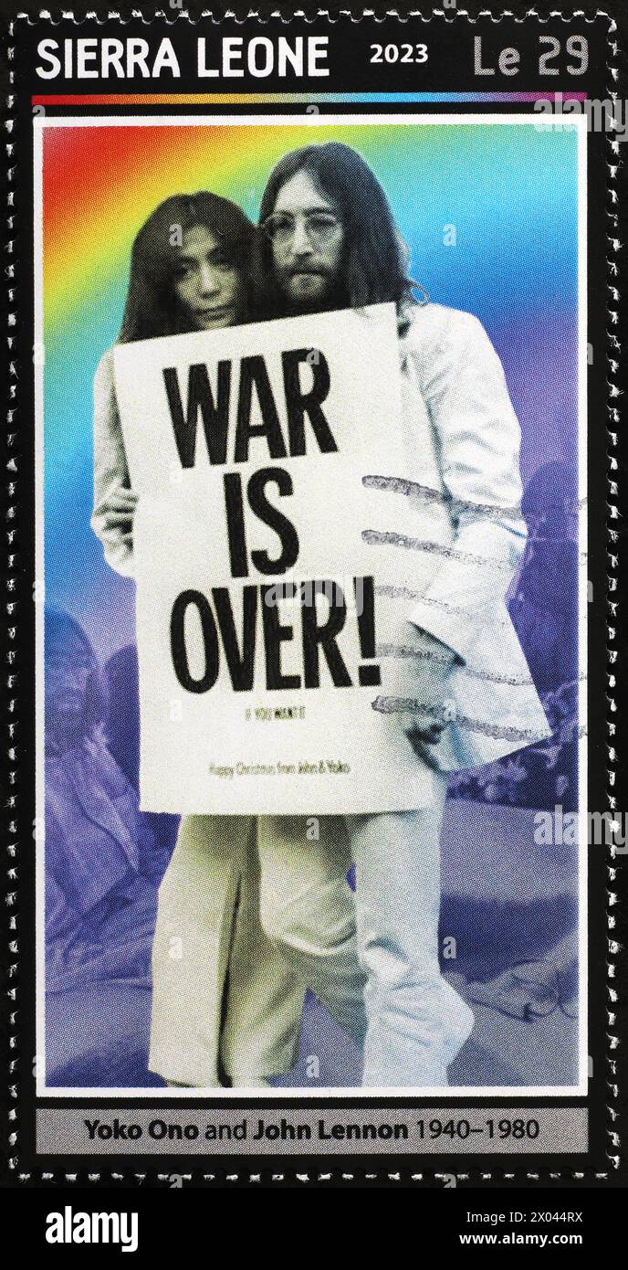 Lennon et Yoko Ono avec le signe 'War is over' sur le timbre Banque D'Images