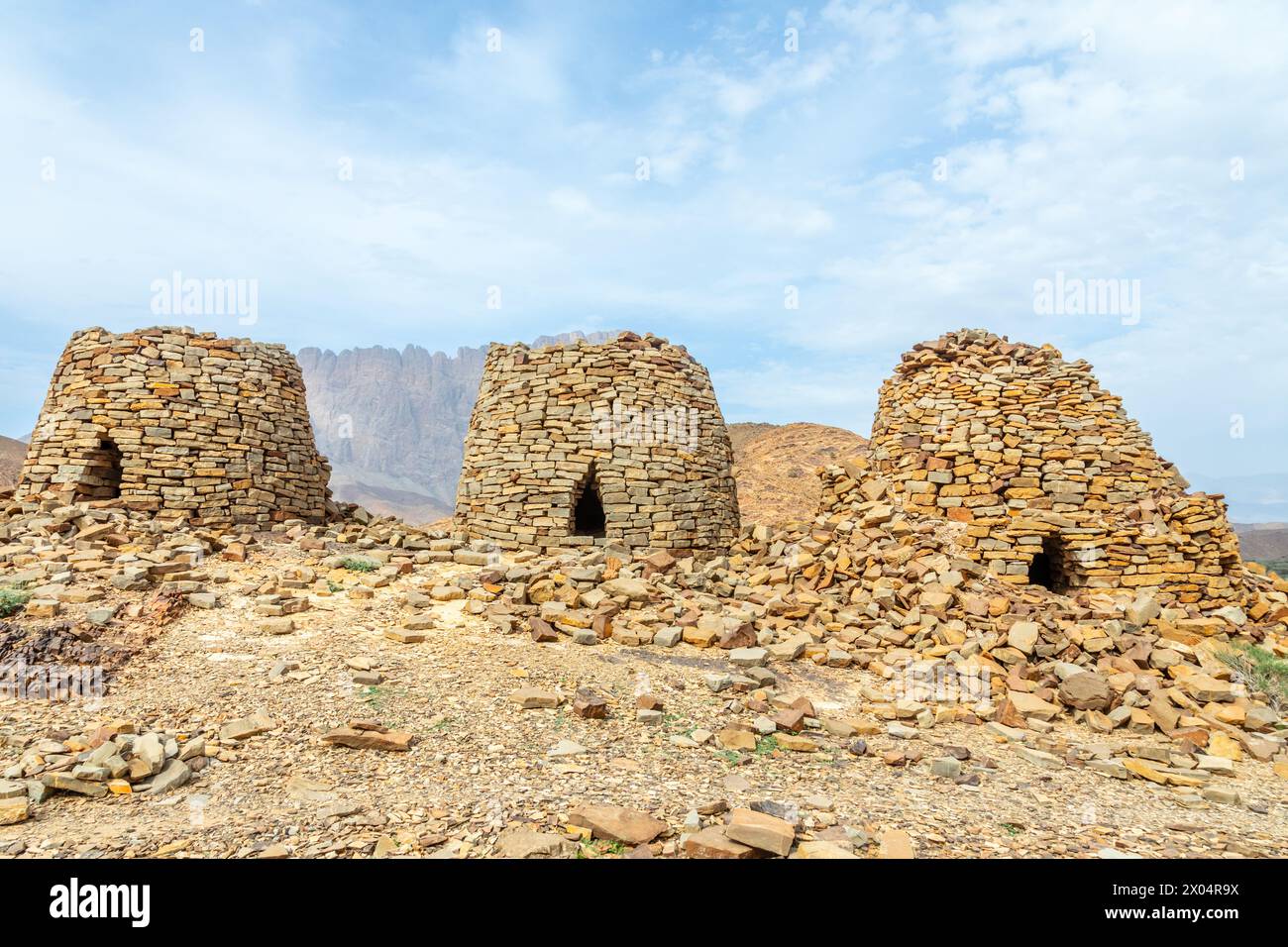 Anciennes tombes de ruches en pierre avec Jebel Misht montagne en arrière-plan, site archéologique près d'al-Ayn, sultanat Oman Banque D'Images