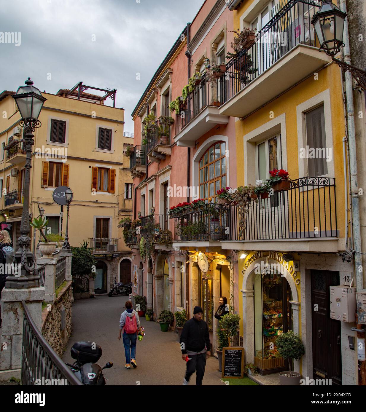 Boutiques et cafés bordent une petite rue dans la ville sicilienne de Taormina Sicile Banque D'Images