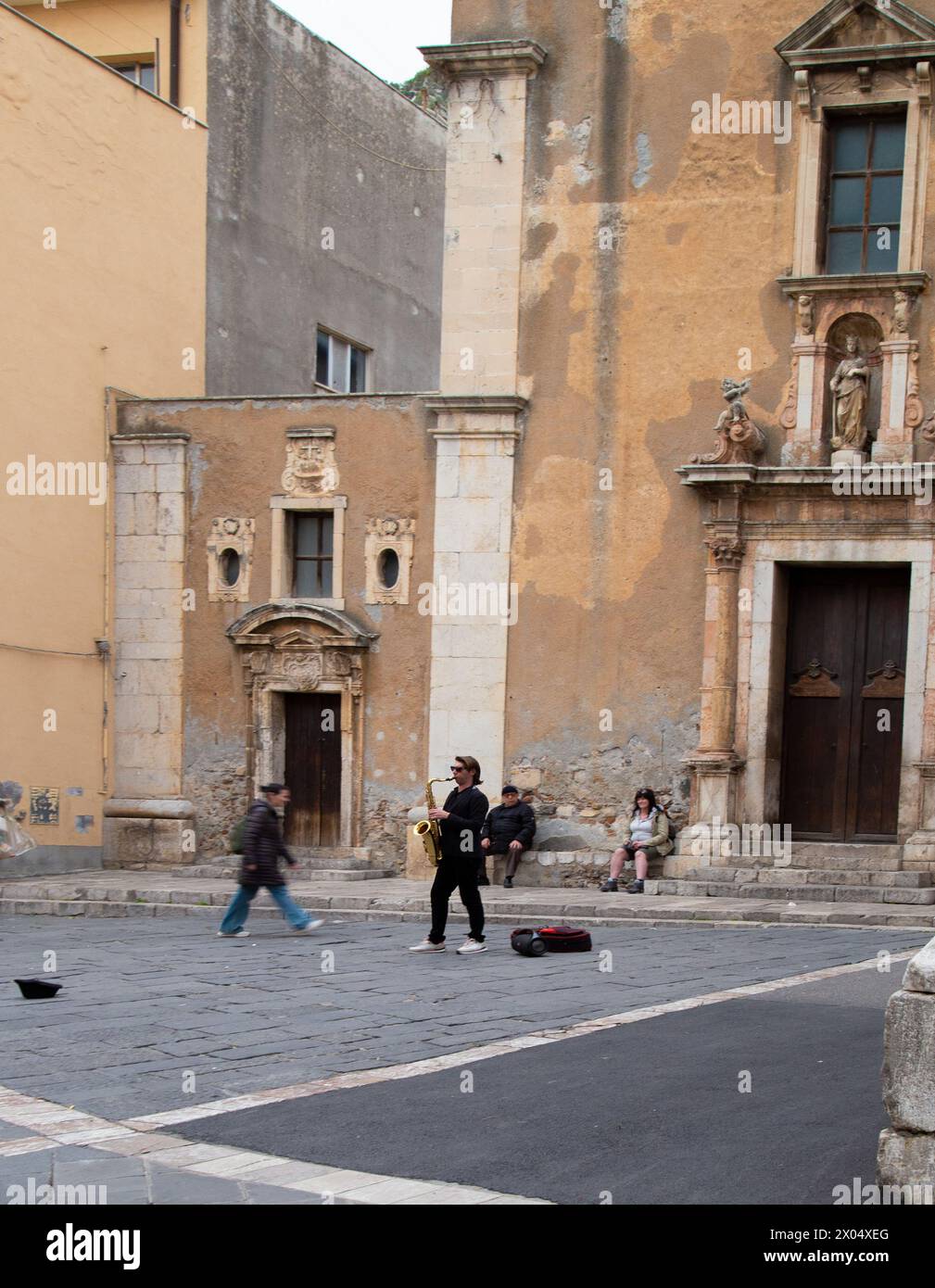 Un musicien de rue joue sur une place dans la ville sicilienne de Taormina, en Italie Banque D'Images