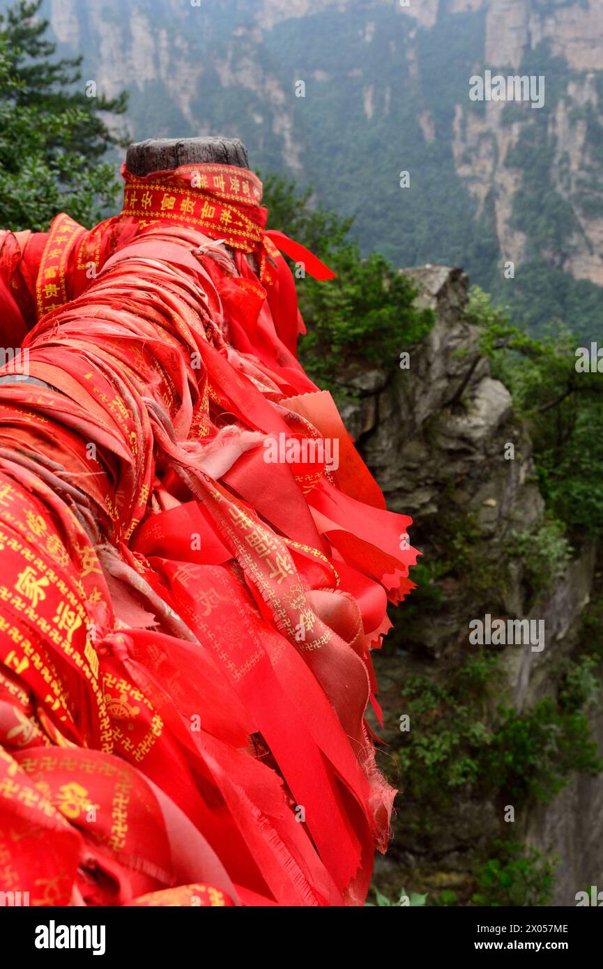 Des rubans de bénédiction rouges et des serrures d'amour bordent les mains courantes dans le parc forestier national de Zhangjiajie dans la zone pittoresque de Wulingyuan, en Chine. Banque D'Images