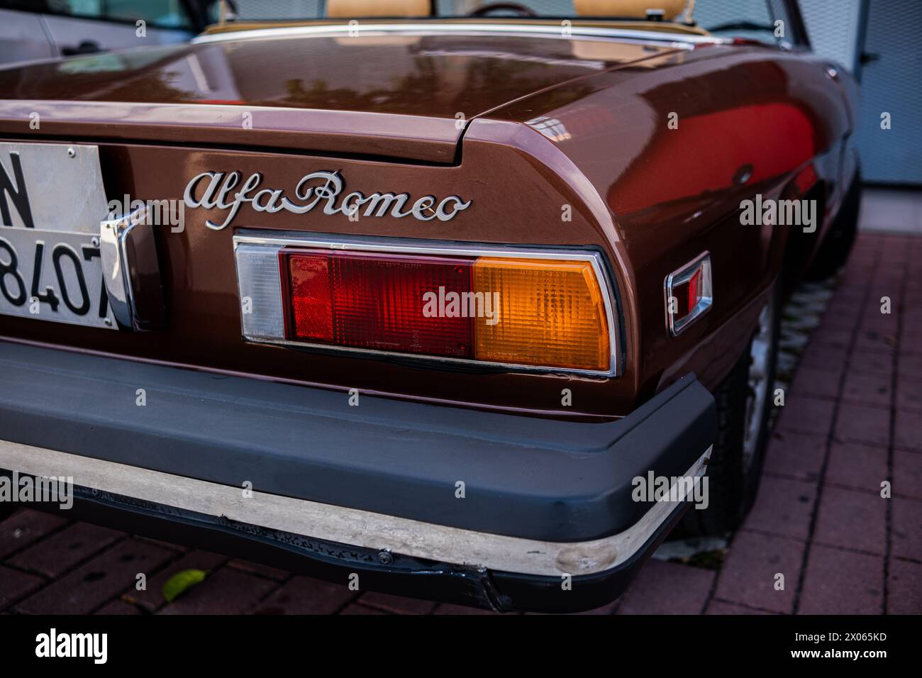 Une vieille voiture vintage parfaitement restaurée Alfa Romeo est garée dans la rue par une journée ensoleillée d'été. Bleu vieux Alfa Romeo sur une rue fleurie. Banque D'Images