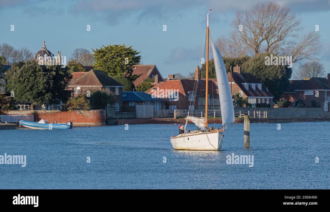 Un yacht naviguant à travers l'extrémité supérieure du port de Chichester à Langstone vu du pont de Langstone, Portsmouth, Hampshire, Angleterre, Royaume-Uni. Banque D'Images
