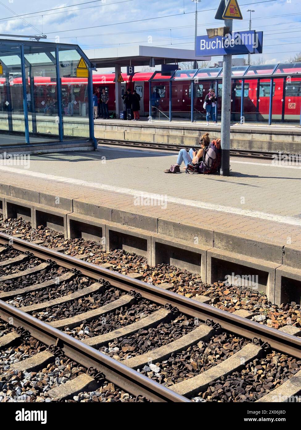 Une femme routard attend le train à la gare de Buchloe le 27 mars 2024 à Augsbourg, en Allemagne Banque D'Images