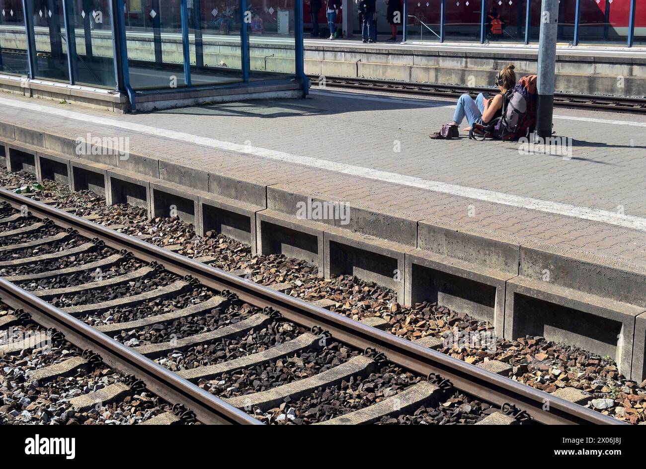 Une femme routard attend le train à la gare de Buchloe le 27 mars 2024 à Augsbourg, en Allemagne Banque D'Images