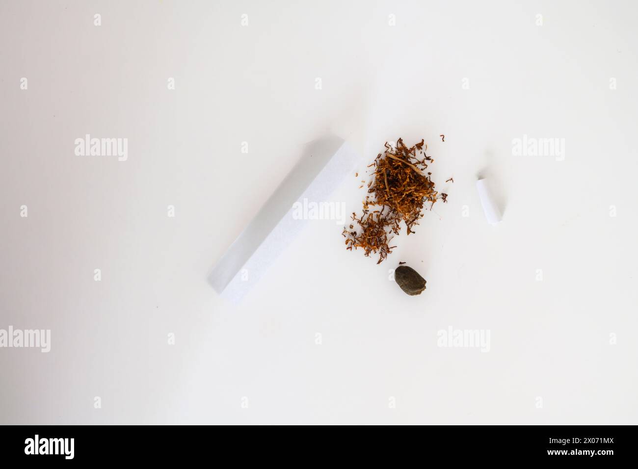 jeune adulte féminin méconnaissable préparer le joint de cigarette de tabac de haschisch de fumée avec filtre à la maison sur la table blanche pour la santé personnelle détendez-nous Banque D'Images