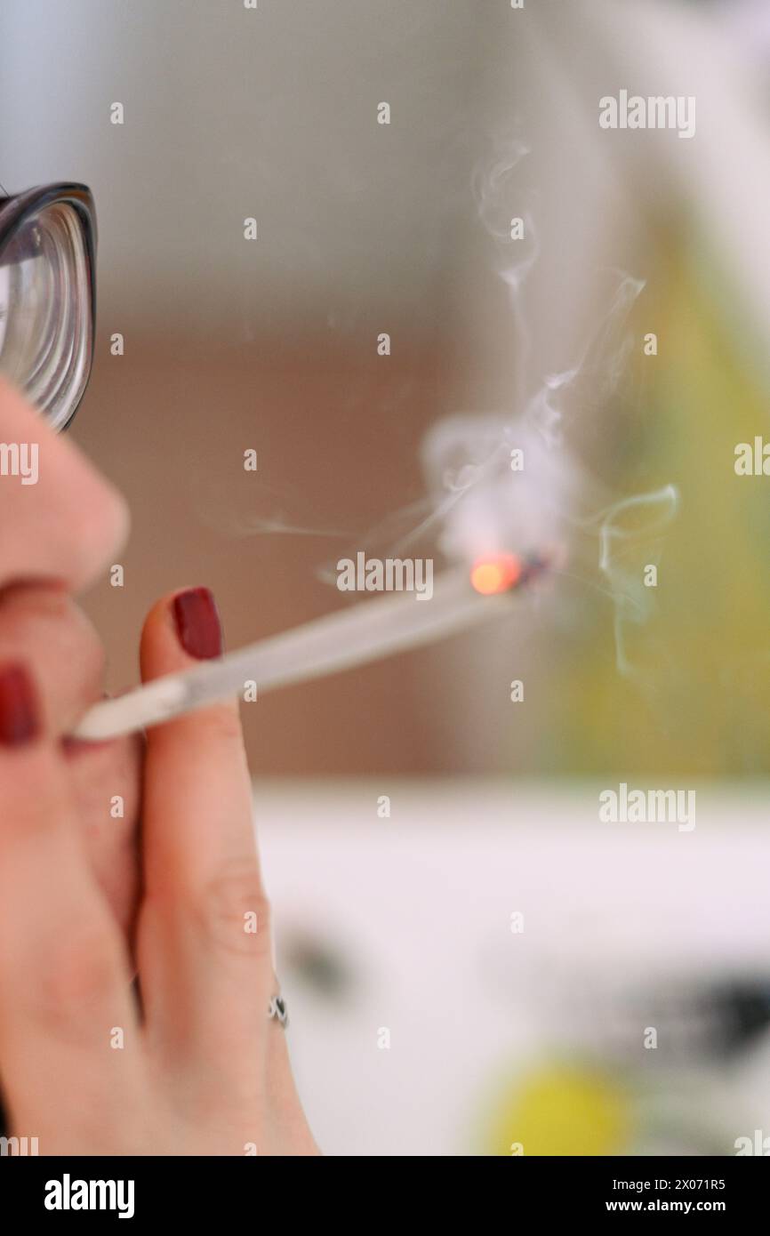 jeune adulte féminin méconnaissable préparer le joint de cigarette de tabac de haschisch de fumée avec filtre à la maison sur la table blanche pour la santé personnelle détendez-nous Banque D'Images