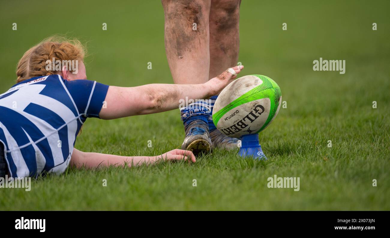 Joueuses de rugby amateur féminines jouant un jeu de rugby et donnant un coup de pied au ballon de rugby pour 2 points supplémentaires. Banque D'Images