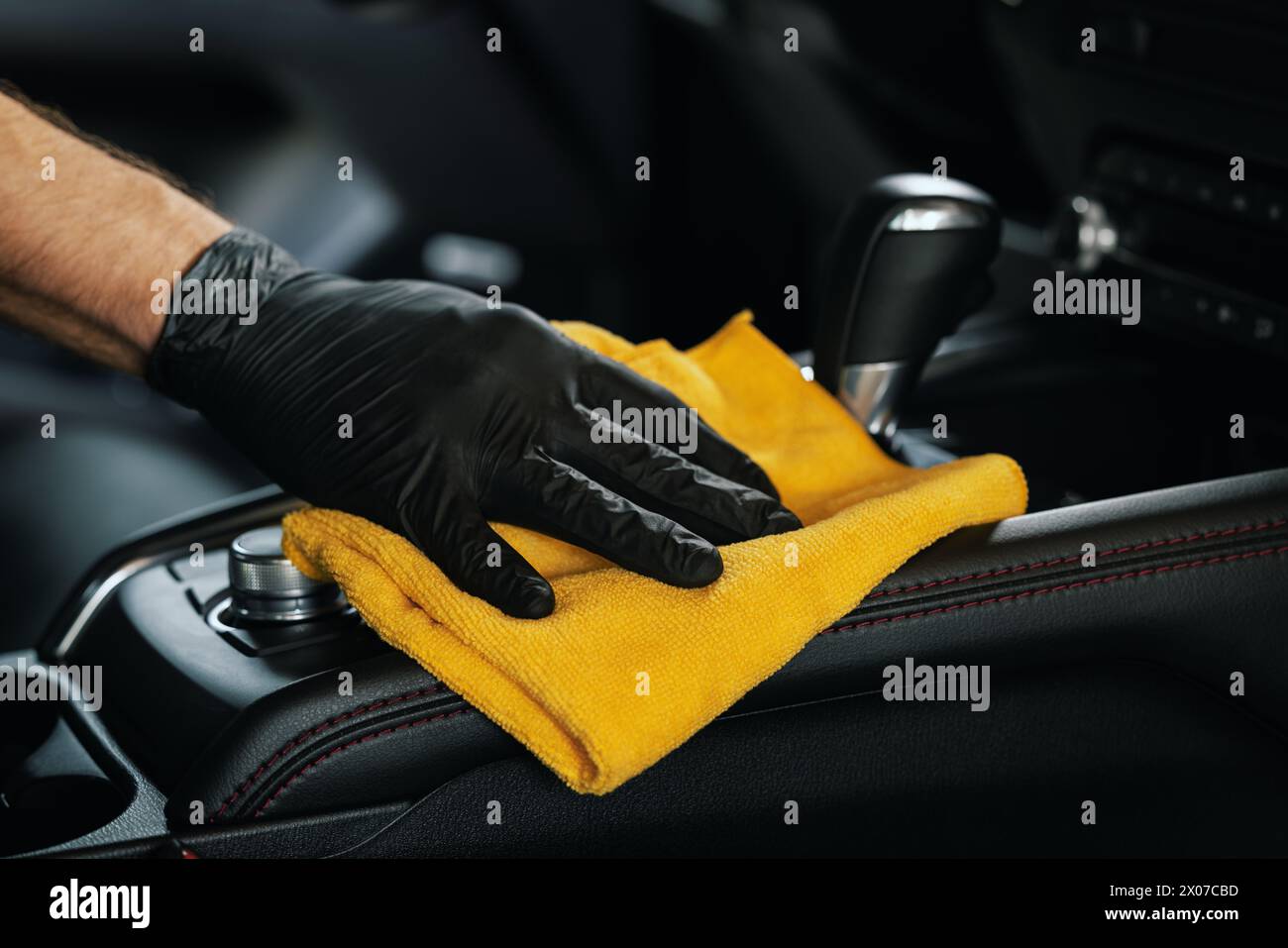 nettoyage de l'intérieur d'une voiture. gros plan de la main avec un chiffon en microfibre sur la console centrale Banque D'Images