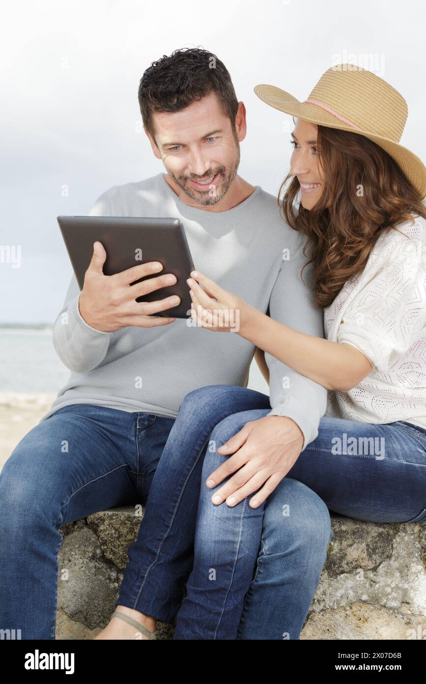 couple utilisant une tablette numérique à l'extérieur Banque D'Images