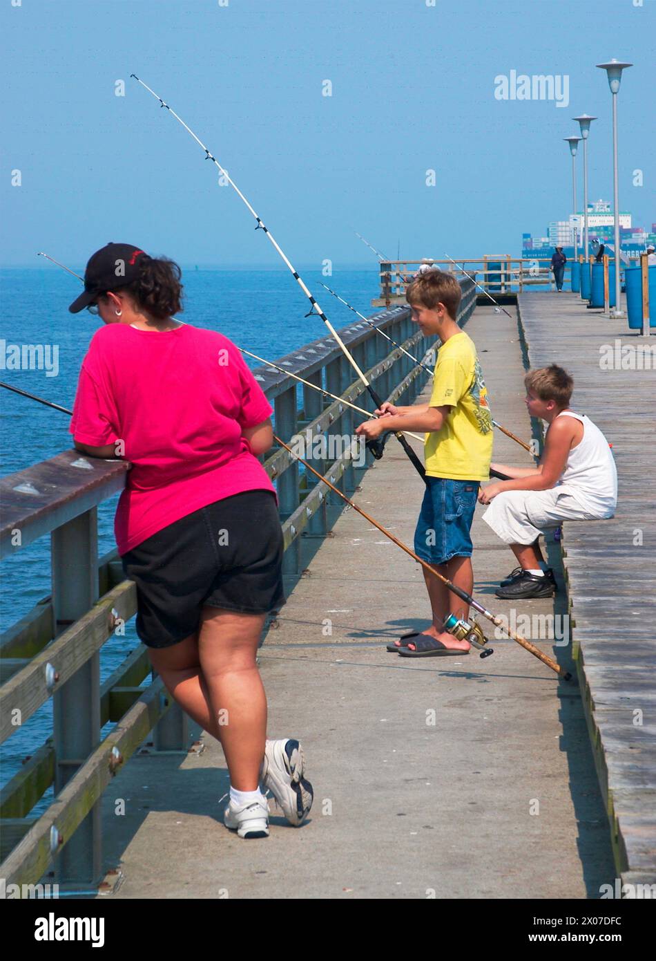 Mère et ses fils pêchent ensemble le long de la rive de la baie de Chesapeake en Virginie, aux États-Unis. Banque D'Images