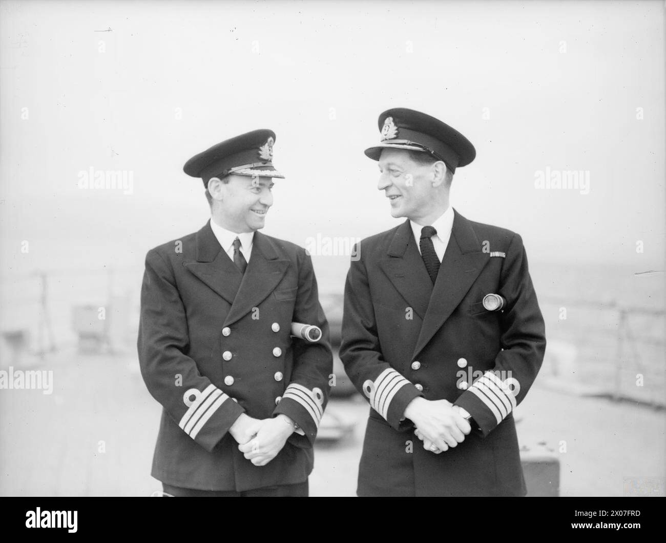 Le 15 octobre 1942 à Greenock, Fife adopte le nouveau croiseur de classe Dido HMS Bellona. Le commandant A.R. Murray-Smith et le capitaine C.F. Norris étaient présents lors de la remise cérémonielle de la plaque commémorative du comté. Banque D'Images
