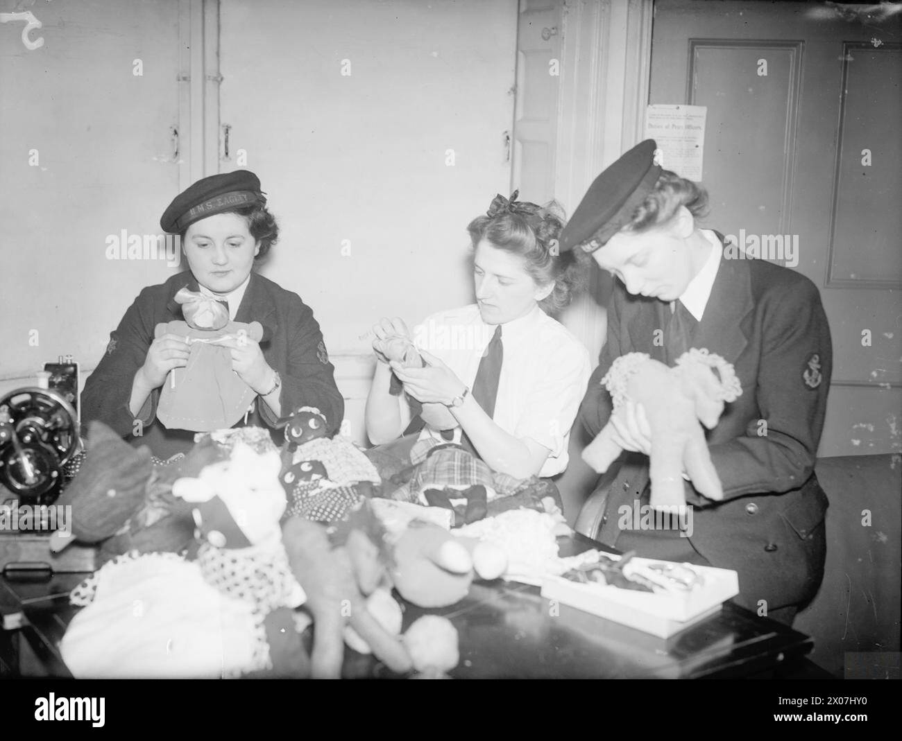 Des membres du Women’s Royal Naval Service (Wrens) fabriquent des poupées et des animaux jouets à partir de vieux bas pour un arbre de Noël pour enfants à Liverpool, en décembre 1942. Banque D'Images