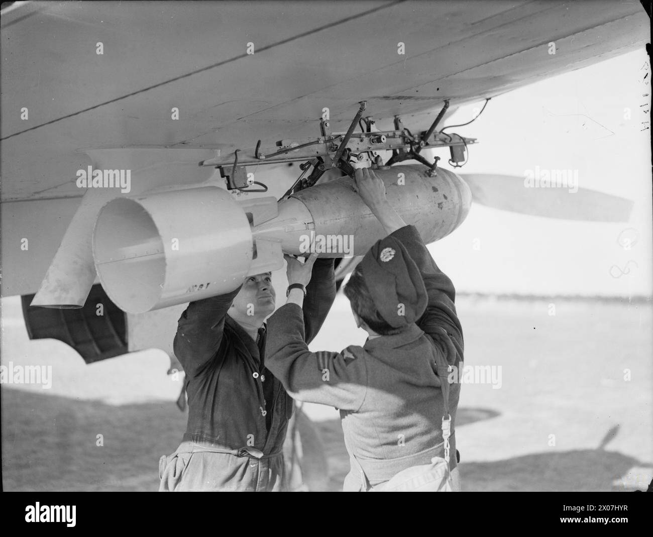 Les armuriers du No. 42 Squadron RAF à Leuchars, Fife, chargèrent une bombe polyvalente de 250 lb sur l'aile d'un Bristol Beaufort lors des opérations du Coastal Command, 1939-1945. Banque D'Images
