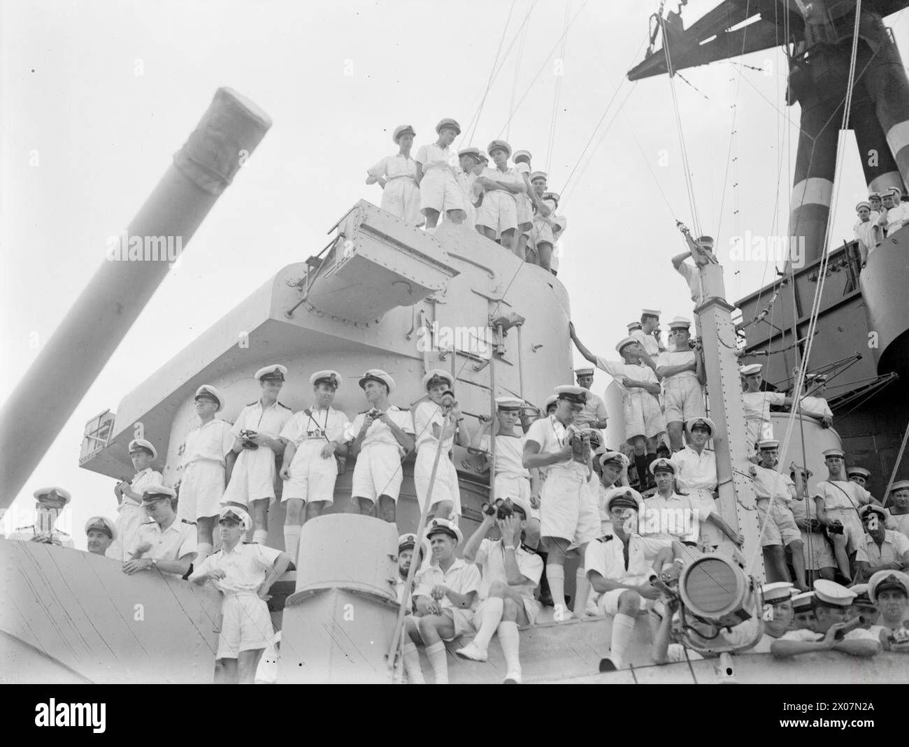 CONFÉRENCE DE PENANG À BORD DU HMS NELSON. DU 28 AOÛT AU 2 SEPTEMBRE 1945, À BORD DU CUIRASSÉ BRITANNIQUE HMS NELSON, NAVIRE AMIRAL DU VICE-AMIRAL H T C WALKER. PENDANT LA REDDITION DE PENANG ET LES NÉGOCIATIONS DE RÉOCCUPATION. LE CONTRE-AMIRAL UZUNI ET LE GOUVERNEUR JAPONAIS DE PENANG SIGNÈRENT POUR LES JAPONAIS, APRÈS QUOI LES DOCUMENTS D'ACCORD FURENT SIGNÉS PAR LE VICE-AMIRAL H. T. C. WALKER À 12 H 2115 LE 1ER SEPTEMBRE 1945. LES ROYAL MARINES DE LA FLOTTE BRITANNIQUE DES INDES ORIENTALES ONT OFFICIELLEMENT REPRIS L'ÎLE LE 3 SEPTEMBRE 1945. - Galerie des officiers et des hommes du HMS NELSON regardant le bateau des officiers de liaison japonais arriver Banque D'Images