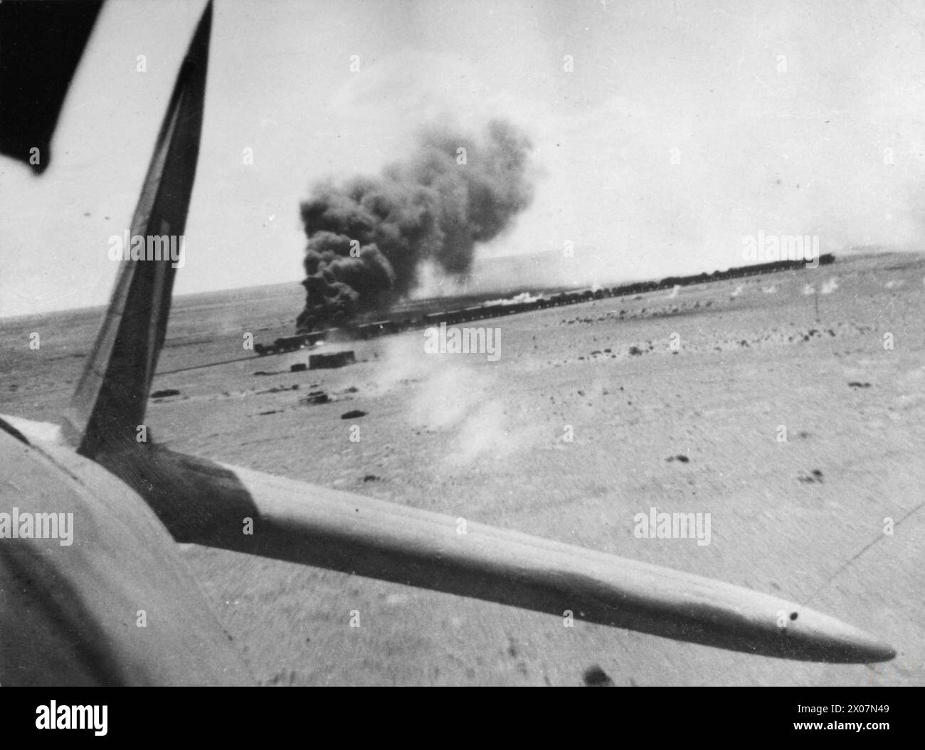 OPÉRATIONS DE LA ROYAL AIR FORCE AU MOYEN-ORIENT ET EN AFRIQUE DU NORD, 1939-1943. - Un train de ravitaillement ennemi transportant des canons et des munitions est incendié près de Bir Abu Mischeifa, lors d'une attaque par quatre Bristol Beaufighters du No. 252 Squadron RAF et trois Bristol Bisleys du No. 15 Squadron SAAF. La photographie a été prise de la position de l'observateur dans l'un des Beaufighter, alors qu'il s'envolait loin de la cible Royal Air Force, unité de maintenance, 252, Force aérienne sud-africaine, Sqdn, 15 Banque D'Images