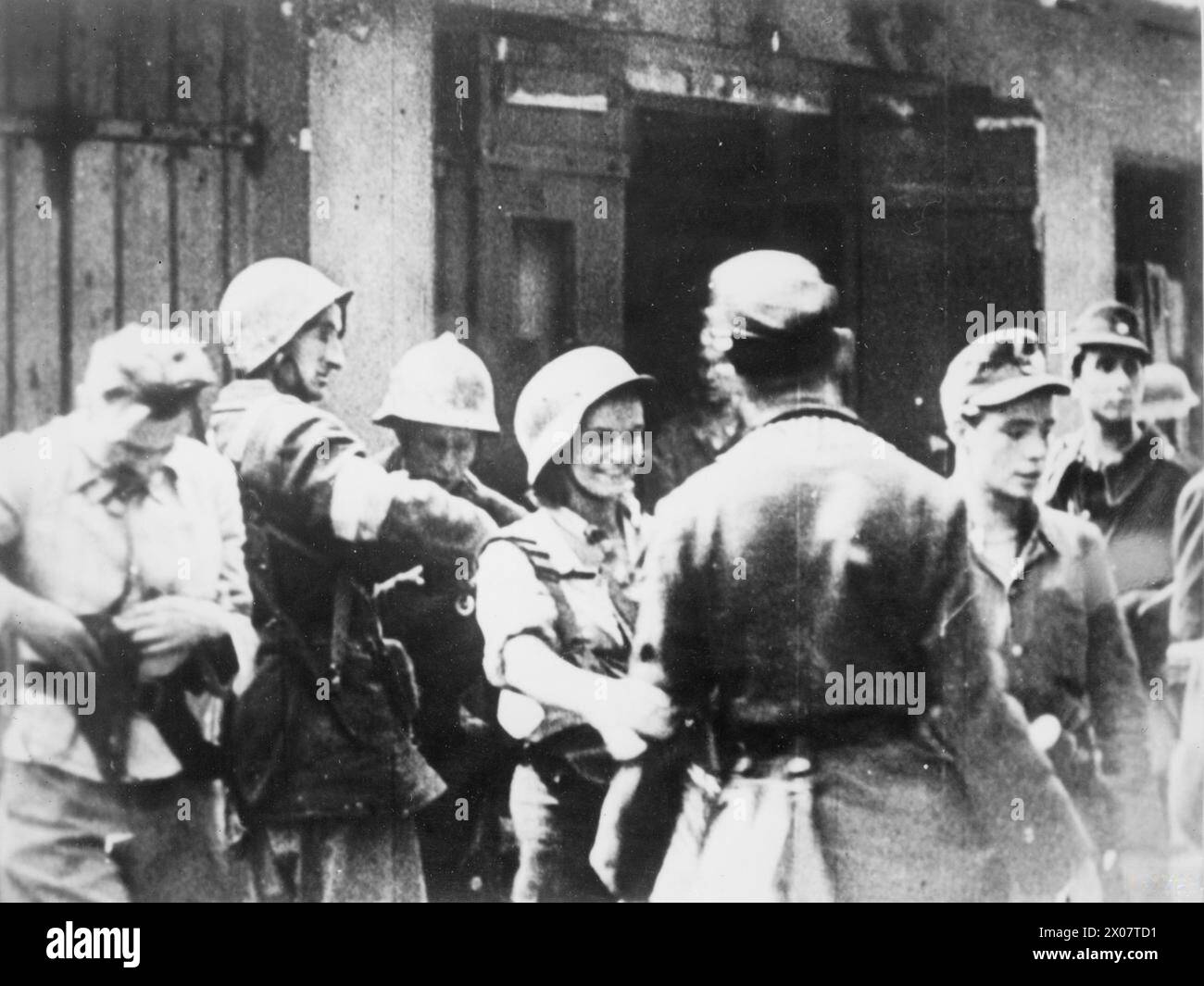 Le 23 août 1944, des soldats du peloton no 2 de la 4e compagnie du groupement tactique Bartkiewicz de l'Armée de l'intérieur polonaise occupent la cour du quartier général de la police au 1 Krakowskie Przedmieście à Varsovie pendant l'insurrection de Varsovie. Le caporal Danuta Szczepańska-Kuczyk, une coureuse d'expédition, est présent et porte un casque allemand. Banque D'Images