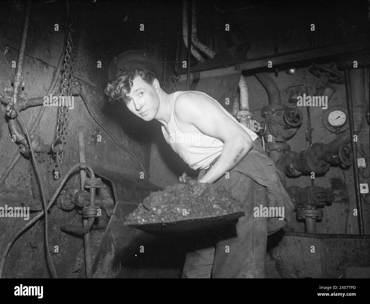 Le HMS Rosemary, un sloop britannique de 30 ans et le seul navire à charbon de son type en service actif, opère le 31 février 1945 à Greenock, avec le stoker Albert Spencer qui s'occupe des incendies. Banque D'Images