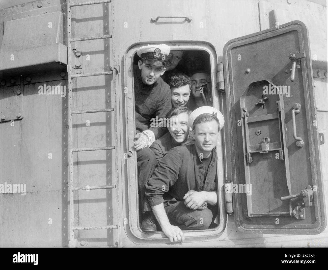 Après avoir coulé un convoi ennemi à destination de la Tunisie les 1er et 2 décembre 1942, les membres de l'équipage du HMS Argonaut sont photographiés souriants dans une tourelle avancée après l'opération. Banque D'Images