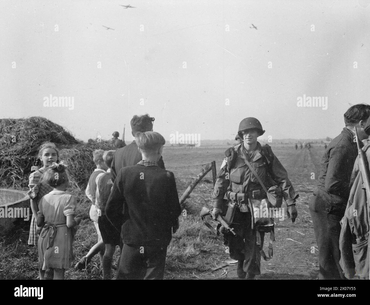Des enfants hollandais saluent les parachutistes du 506th Parachute Infantry Regiment, de la 101st Airborne Division américaine, après avoir atterri sur la Drop zone B près de son lors de l'opération Market Garden, le 17 septembre 1944. Banque D'Images