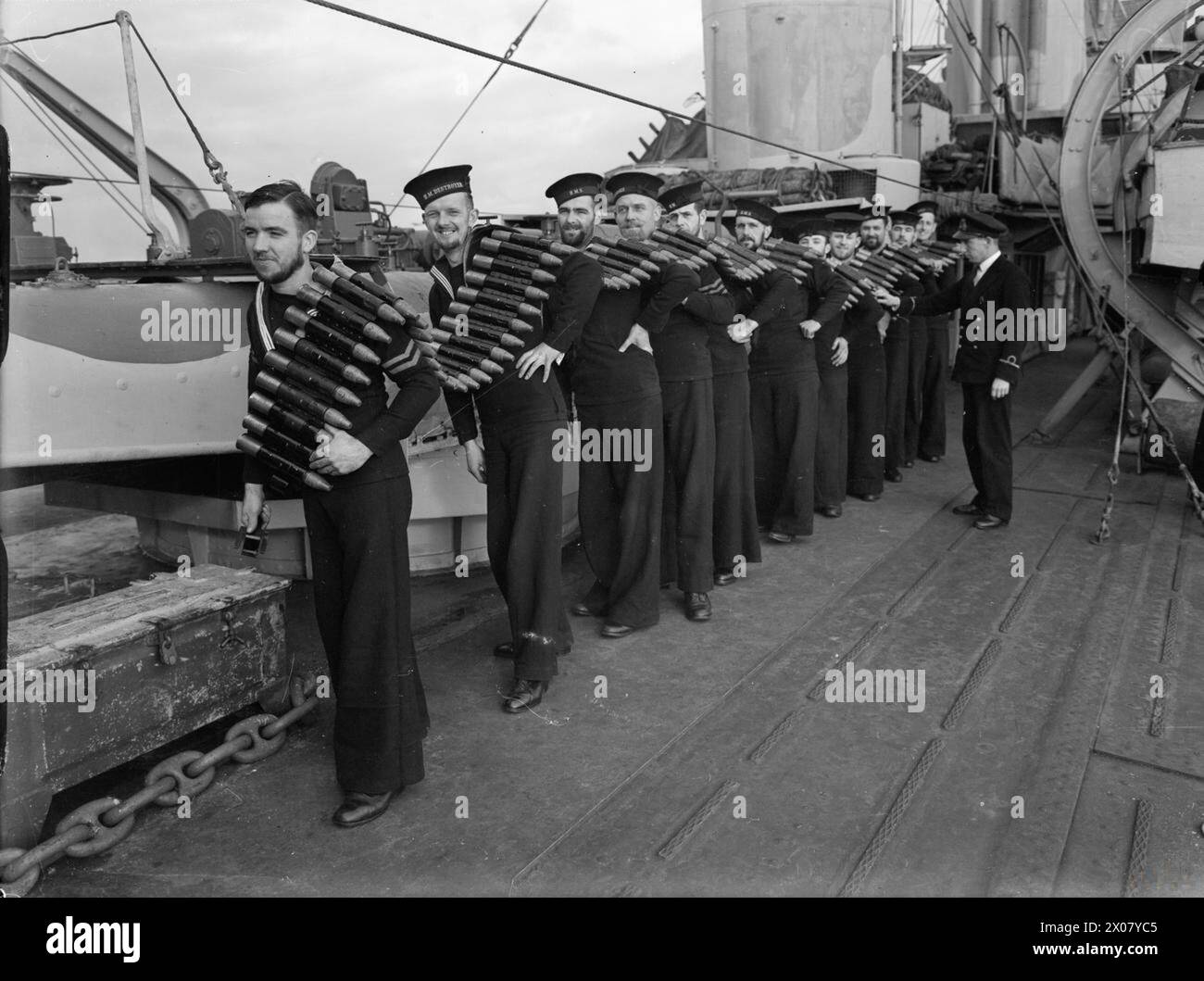 Les marins à bord du HMS Ashanti transportent des obus de 2 livres depuis le magazine jusqu'à la plate-forme de canon Vickers Mark VIII « pom pom » pendant la seconde Guerre mondiale à Scapa Flow. Banque D'Images