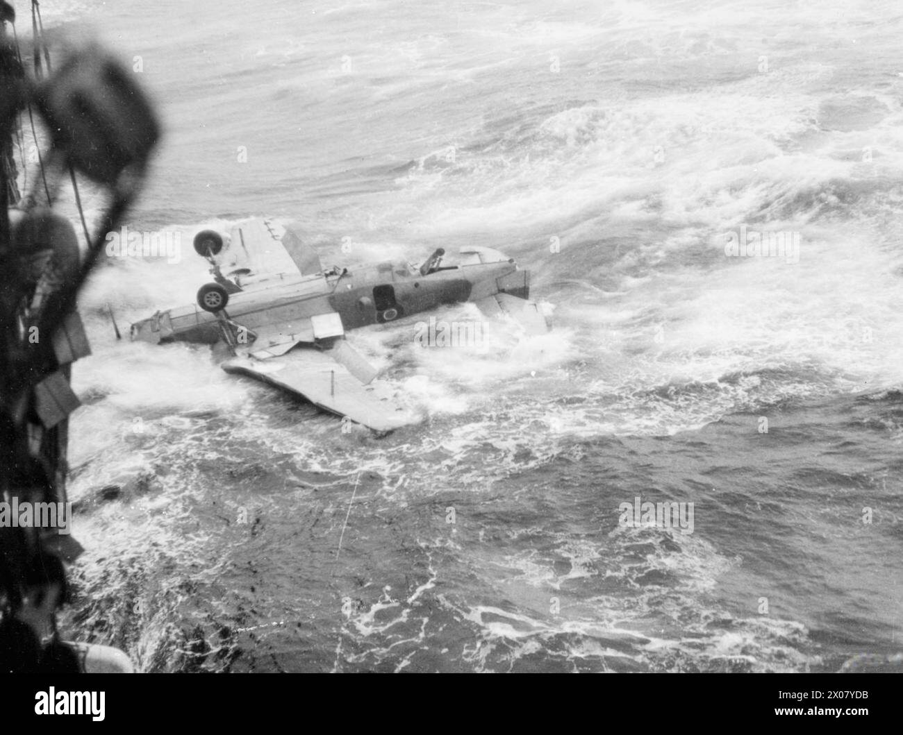 SON BON TRAVAIL A ÉTÉ FAIT. SEPTEMBRE 1944, À BORD DU NCSM NABOB EN MER. LE DERNIER DE L'AVION AVENGER A VOLÉ DANS UNE NUIT BRUMEUSE À PARTIR DU PORTE-AVIONS NMC NABOB PAR LE LIEUTENANT CDR (A) ROBERT H BRADSHAW, DSC ET 2 BARS, RN, ET SON ÉQUIPAGE POUR GARDER À BAY UN U-BOOT MANŒUVRANT POUR UNE MORT QUI N'A JAMAIS EU LIEU. - La machine du lieutenant CdR Bradshaw passe sur le côté après l'atterrissage sur le porte-avions Banque D'Images