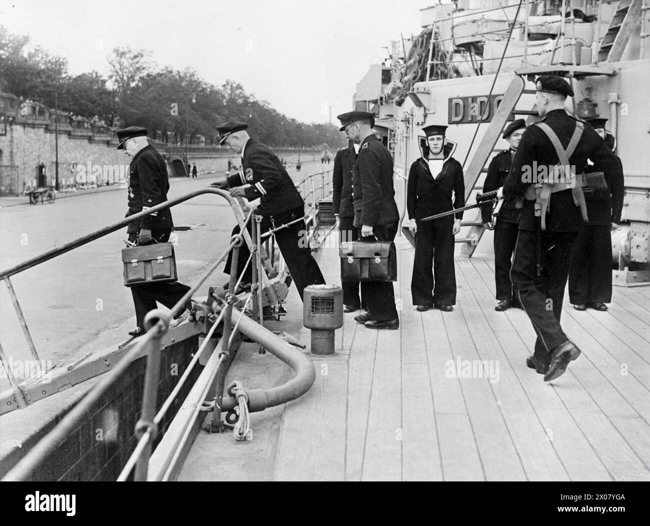 LES OFFICIERS DE LA MARINE ALLEMANDE À BORD DU HMS DIDO REÇOIVENT DES INSTRUCTIONS POUR DÉSARMER LEURS PROPRES NAVIRES. 14 MAI 1945, À BORD DU HS DIDO À COPENHAGUE. - Les officiers de la marine allemande descendant la passerelle après la rencontre, suivis d'une sentinelle armée Banque D'Images