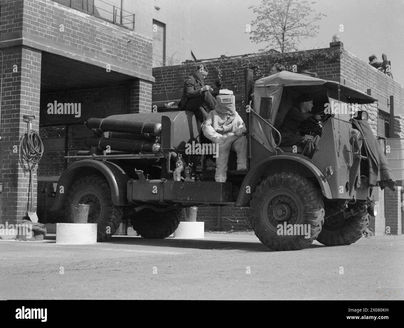 Un crash-tender de la station Crossley type 'T' et son équipage sont prêts pour l'action à la RAF Hornchurch, Essex, entre 1939 et 1945. Le pompier est vêtu d'une combinaison en amiante et positionné devant l'équipement d'extinction d'incendie en mousse. Banque D'Images